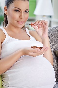 Woman eating almonds; nuts are a source of selenium, important for reproductive healthfor 